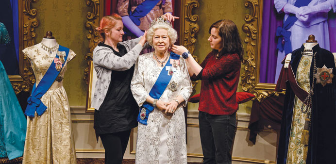 Stylists Jane Anderson (left) and Luisa Compabassi pose with the re-styled wax figure of Queen Elizabeth II during a photocall at Madame Tussauds in c